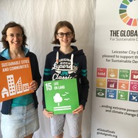 Global Goals 2017 - 4 Woman and girl holding up signs which read "Sustainable cities and communities" and "Life on land"