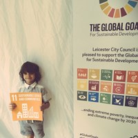 Global Goals 2017 - 5 Young boy holding up a sign which reads "Sustainable cities and communities"