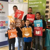 Global Goals 2017 - 10 Group of adults and children all holding up various coloured signs